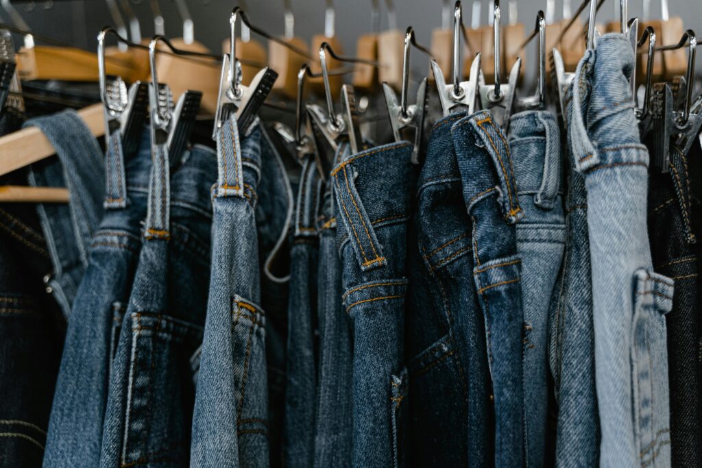Close-up of various denim jeans hanging on a rack, perfect for fashion and retail themes.